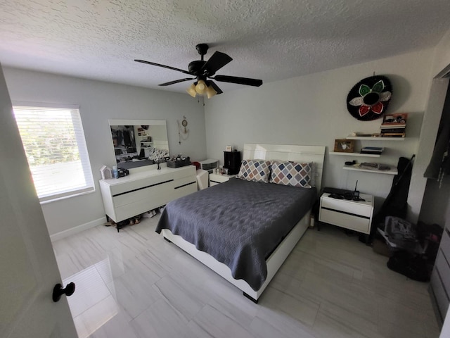 bedroom featuring ceiling fan and a textured ceiling