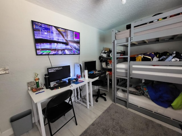 bedroom featuring a textured ceiling and light hardwood / wood-style flooring