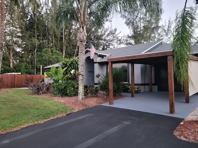 rear view of property featuring a carport and a lawn