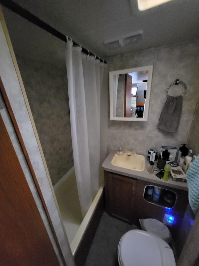 full bathroom with shower / bath combo with shower curtain, sink, and toilet