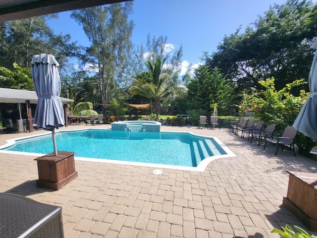 view of pool with an in ground hot tub and a patio