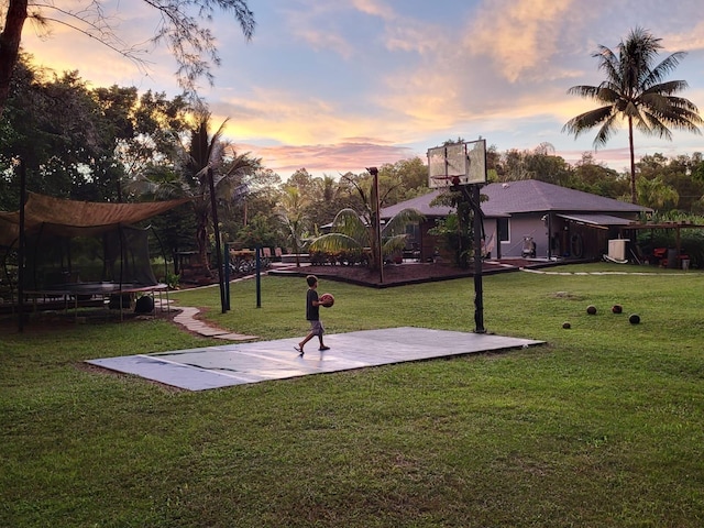 exterior space with a trampoline and a yard