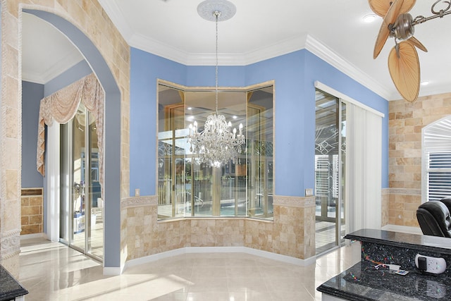 interior space featuring ceiling fan with notable chandelier, crown molding, and tile walls