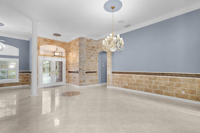 interior space with an inviting chandelier, tile walls, crown molding, and french doors