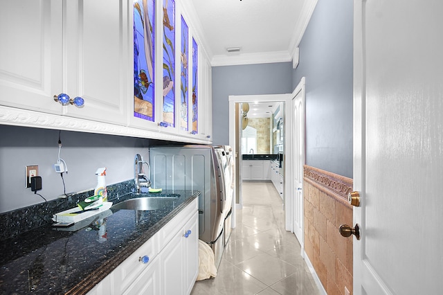 laundry area featuring sink, cabinets, crown molding, washer and clothes dryer, and light tile patterned floors