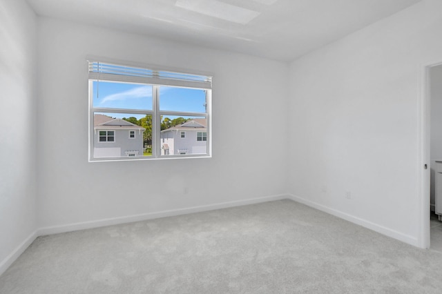 spare room featuring light colored carpet