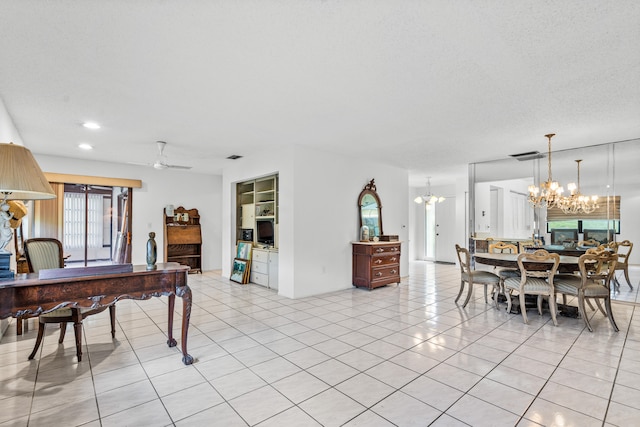 dining room with a textured ceiling, light tile floors, and ceiling fan with notable chandelier