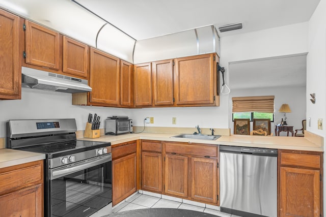 kitchen with stainless steel appliances, sink, and light tile floors