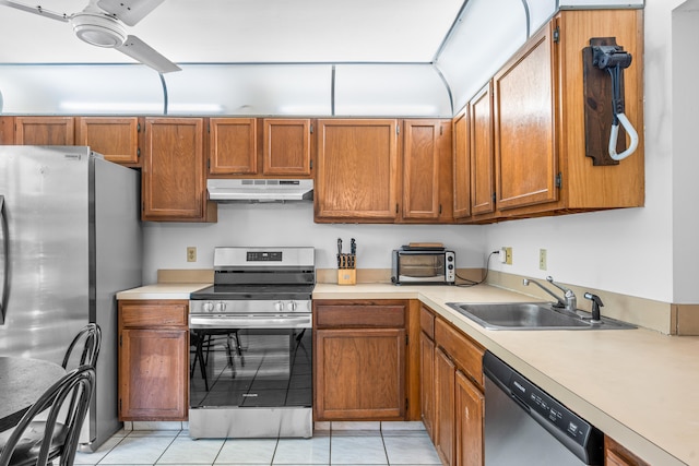 kitchen featuring appliances with stainless steel finishes, sink, light tile flooring, and ceiling fan