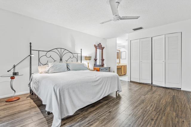 bedroom featuring dark hardwood / wood-style flooring, a closet, ensuite bathroom, ceiling fan, and a textured ceiling