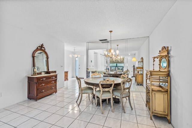 dining room with a textured ceiling, light tile floors, and an inviting chandelier