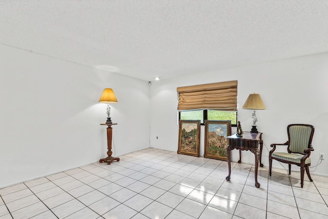 sitting room featuring a textured ceiling and light tile floors