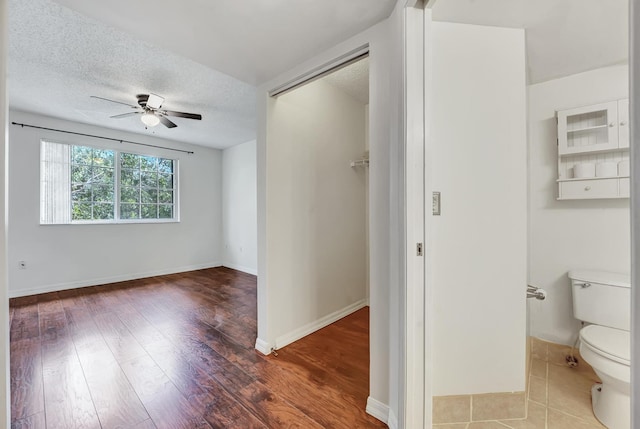 spare room featuring ceiling fan, a textured ceiling, and wood-type flooring