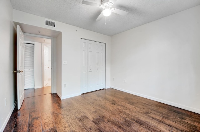 unfurnished bedroom featuring ceiling fan, a textured ceiling, a closet, and hardwood / wood-style floors