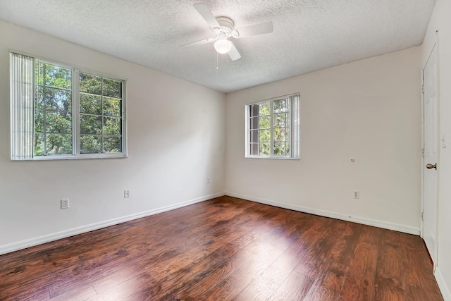 unfurnished room with a healthy amount of sunlight, a textured ceiling, dark hardwood / wood-style floors, and ceiling fan