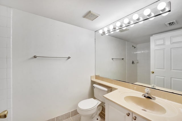 bathroom featuring tile patterned floors, toilet, tiled shower, and vanity