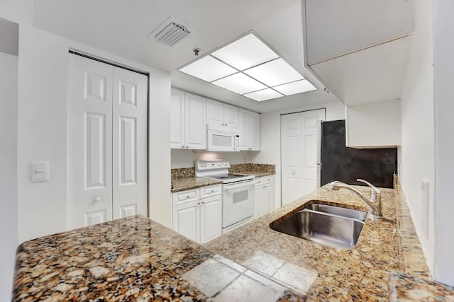 kitchen featuring sink, white appliances, and white cabinets