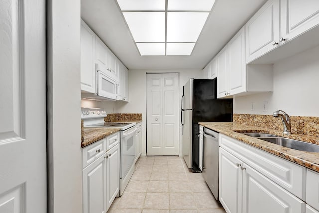 kitchen featuring light stone countertops, white cabinets, appliances with stainless steel finishes, sink, and light tile patterned flooring