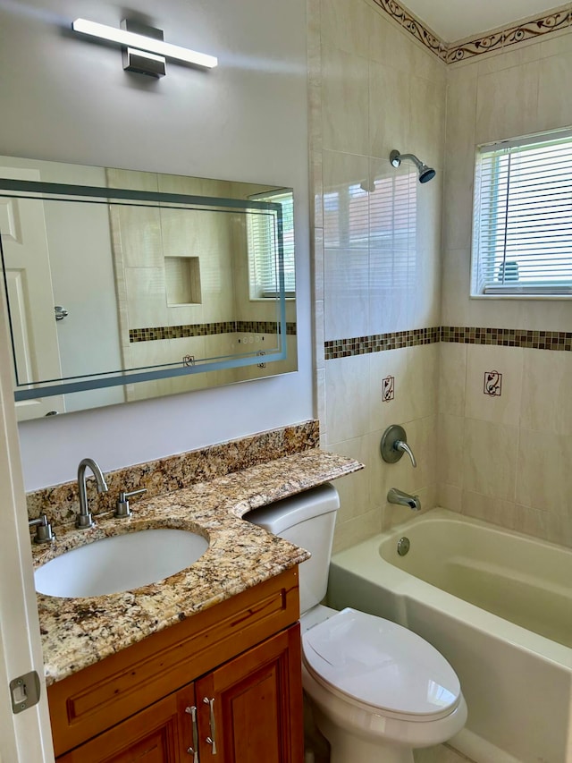 full bathroom featuring toilet, vanity, and tiled shower / bath