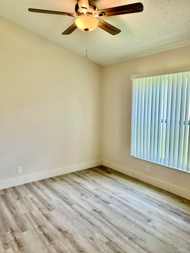 empty room featuring a textured ceiling, ceiling fan, and hardwood / wood-style floors