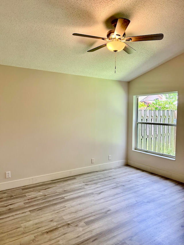 unfurnished room featuring a textured ceiling, light wood-type flooring, and ceiling fan