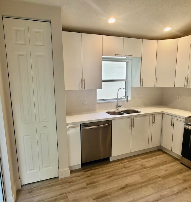 kitchen featuring light hardwood / wood-style floors, appliances with stainless steel finishes, white cabinets, and sink