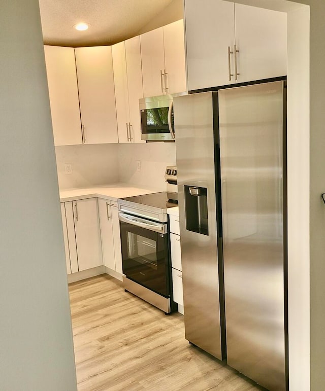 kitchen featuring white cabinetry, appliances with stainless steel finishes, and light wood-type flooring