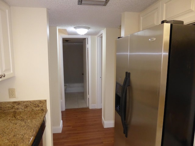 kitchen with white cabinetry, stainless steel fridge with ice dispenser, a textured ceiling, and light hardwood / wood-style flooring