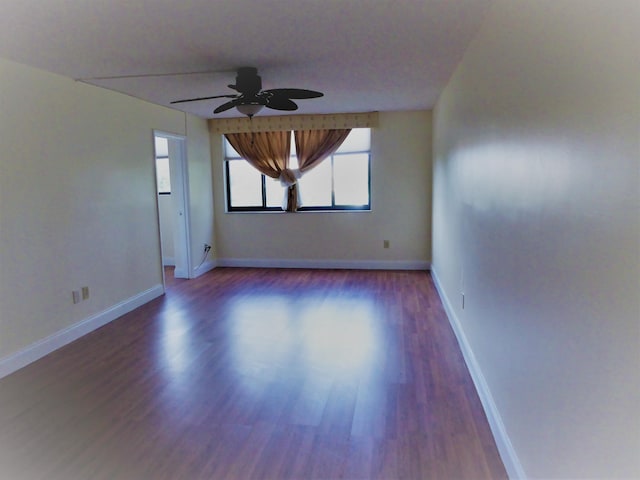 empty room with dark hardwood / wood-style floors and ceiling fan