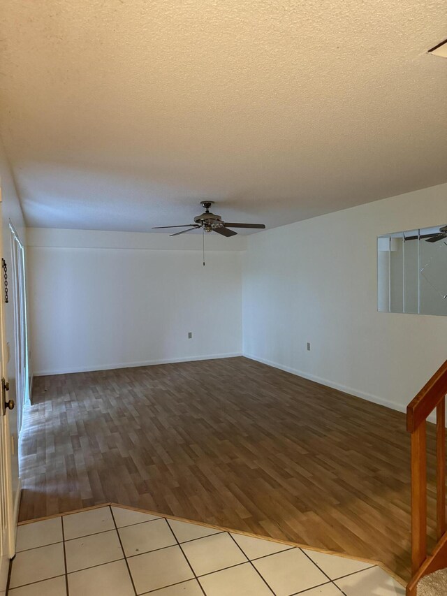 tiled spare room featuring a textured ceiling and ceiling fan