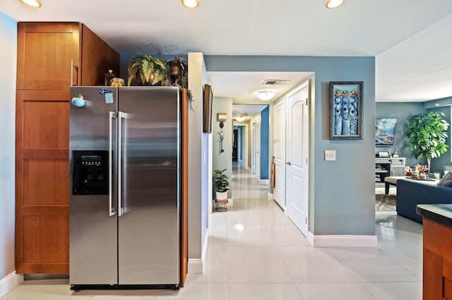 kitchen featuring stainless steel fridge with ice dispenser and light tile patterned floors