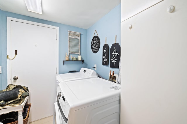 clothes washing area featuring washer and dryer and light tile patterned flooring