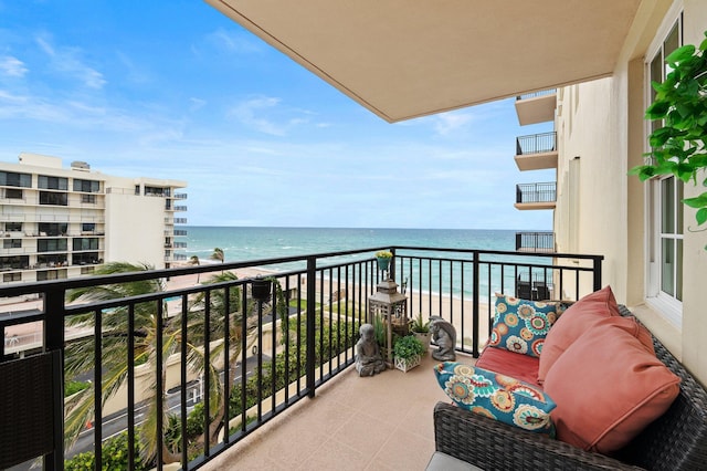 balcony with a water view and a view of the beach