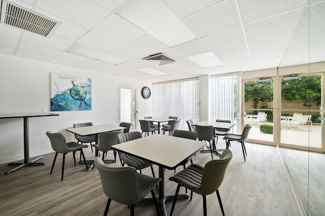 dining room featuring a drop ceiling and wood-type flooring