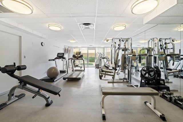 gym with a paneled ceiling and floor to ceiling windows