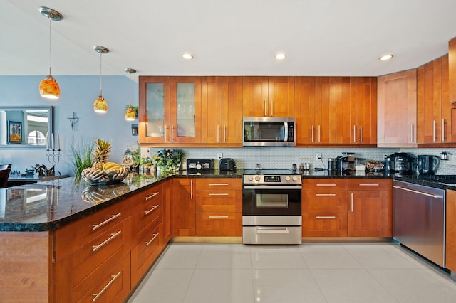 kitchen featuring appliances with stainless steel finishes, backsplash, dark stone counters, light tile patterned floors, and hanging light fixtures