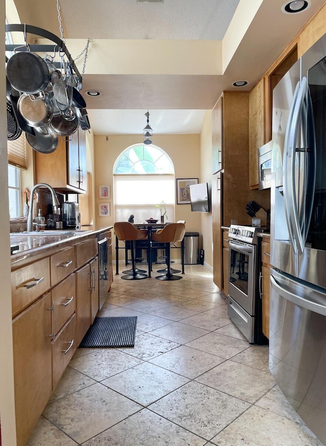 kitchen with stainless steel appliances, a healthy amount of sunlight, and sink