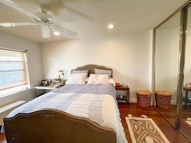 bedroom with a textured ceiling, dark hardwood / wood-style flooring, a closet, and ceiling fan