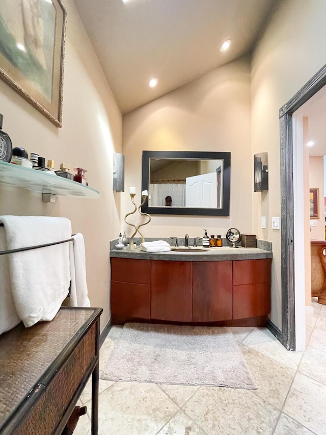 bathroom with vanity and lofted ceiling