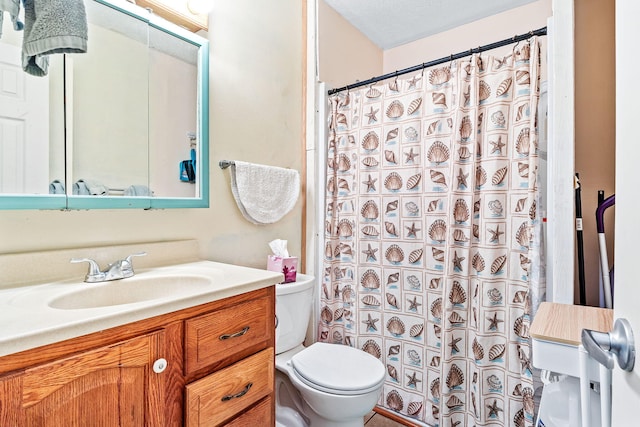 bathroom featuring a textured ceiling, oversized vanity, and toilet