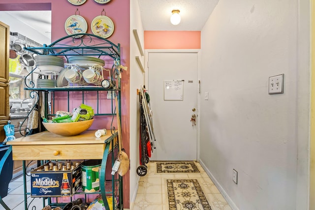 tiled entryway featuring a textured ceiling