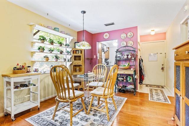 dining space with wood-type flooring