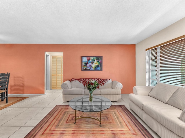 living room featuring a textured ceiling and light tile floors