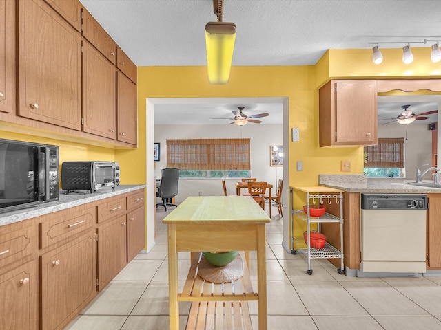 kitchen with ceiling fan, rail lighting, a textured ceiling, white dishwasher, and light tile floors