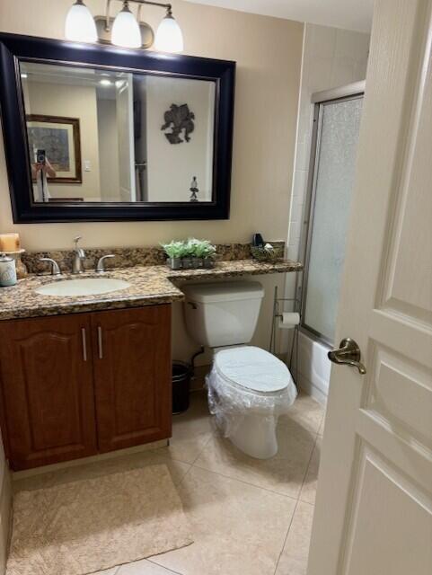 full bathroom featuring tile patterned flooring, vanity, toilet, and bath / shower combo with glass door