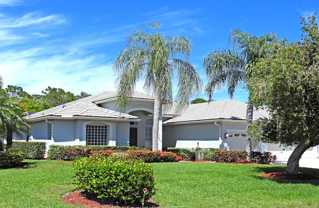 view of front of house with a garage and a front lawn