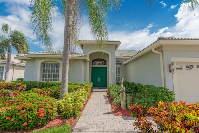 property entrance with an attached garage and stucco siding