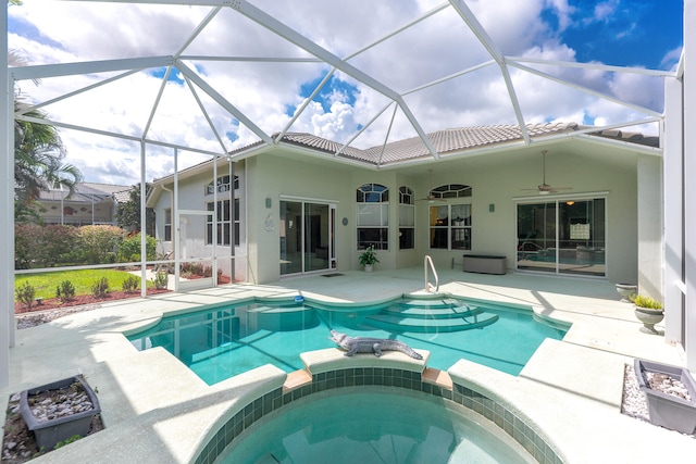 rear view of house featuring glass enclosure, a patio area, a pool with hot tub, and ceiling fan