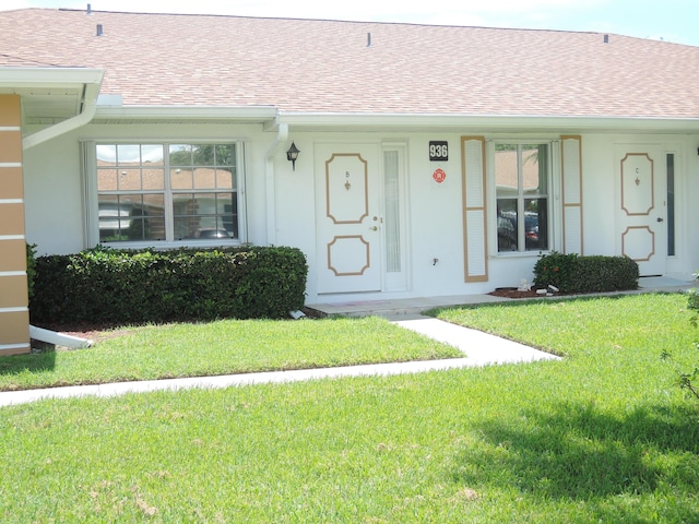 doorway to property featuring a lawn