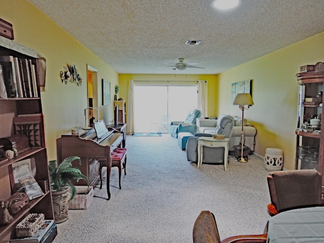 carpeted living room with ceiling fan and a textured ceiling